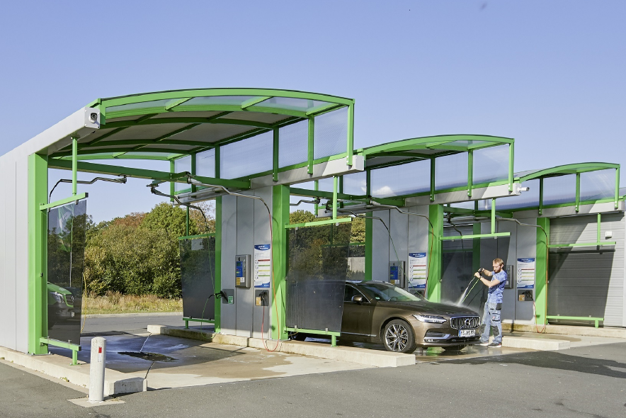 Autowaschboxen mit grünem Tragwerk.