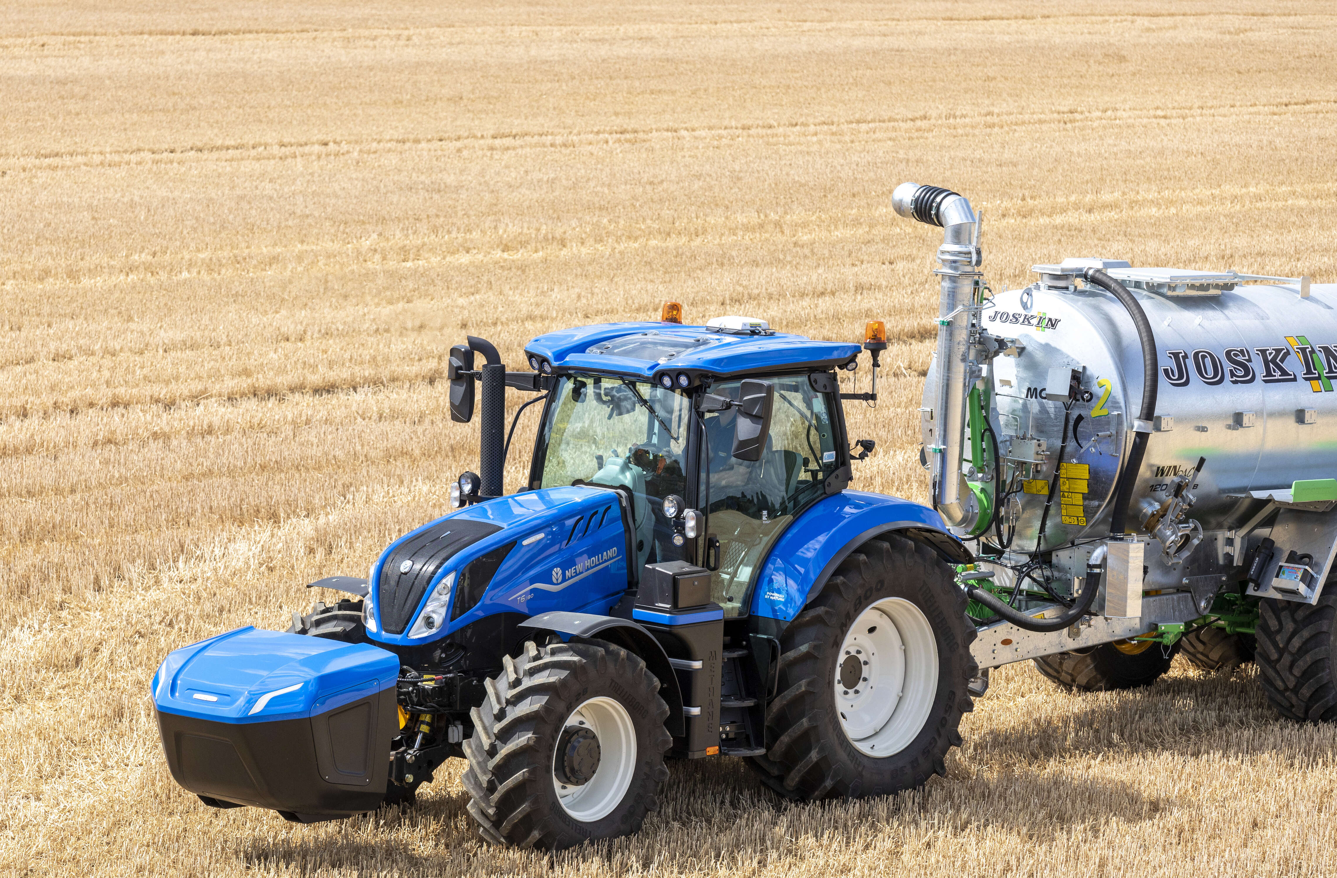 Der Methangasschlepper von New Holland rollt über ein Getreidefeld.