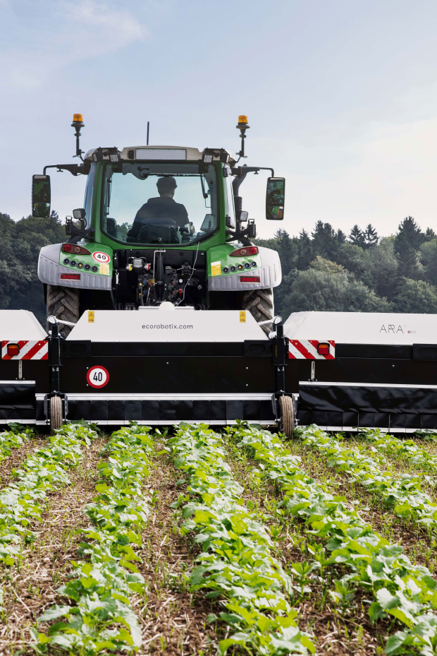 ARA Feldspritze von Ecorobotix hinter Traktor auf Rübenfeld bei Sonnenschein