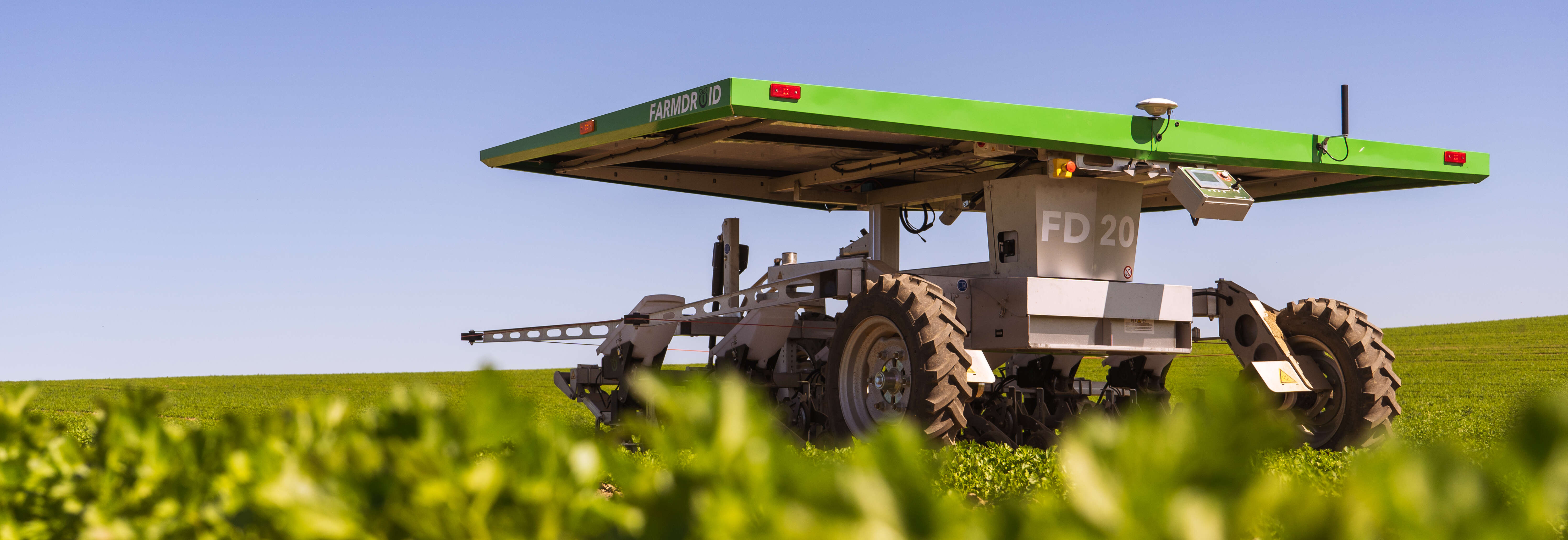 Feldroboter FarmDroid FD20 auf Rübenfeld mit blauem Himmel im Hintergrund