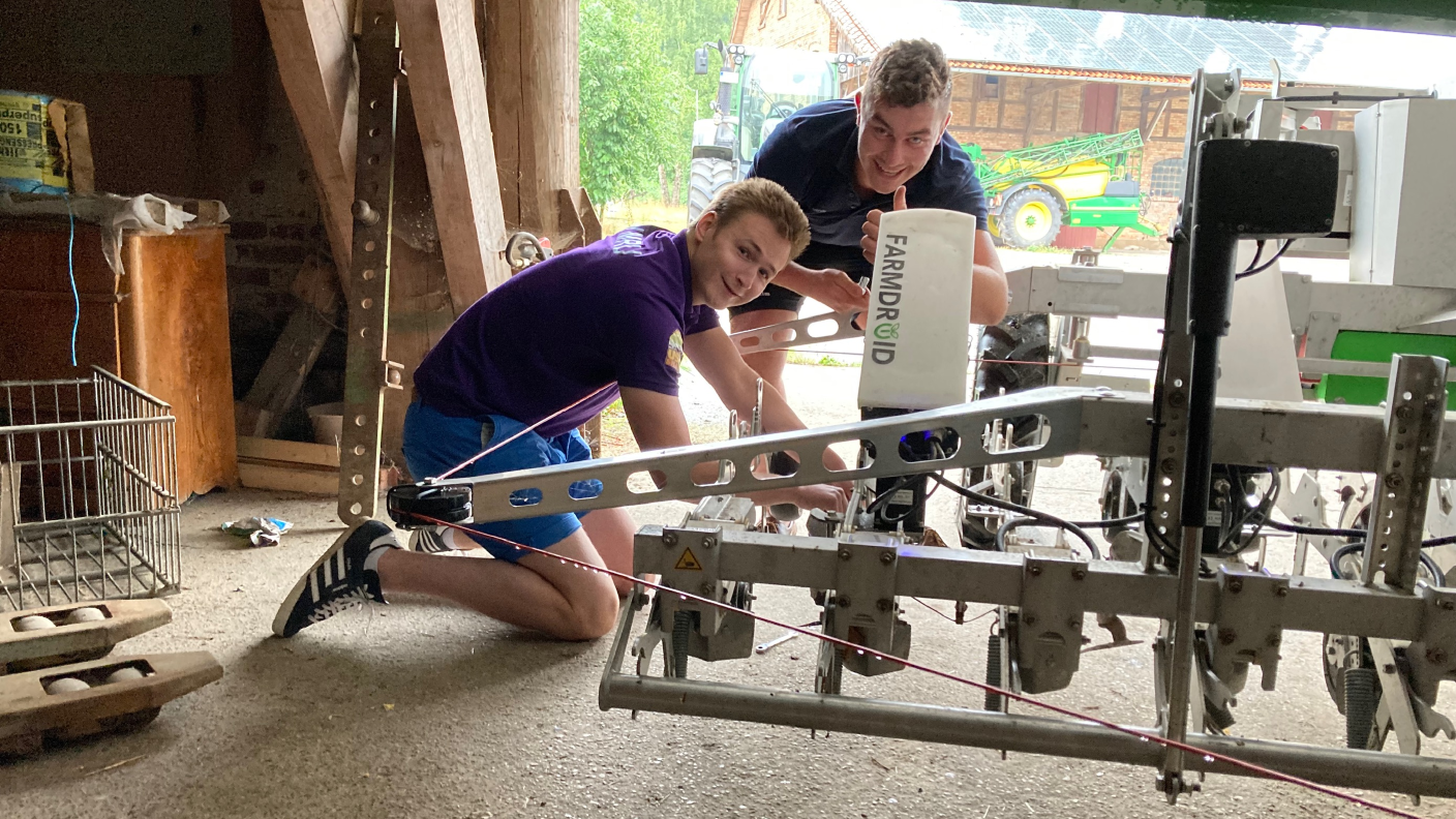 Zwei ausländische Besucher auf der Future Farm inspizieren den Farmdroid FD20