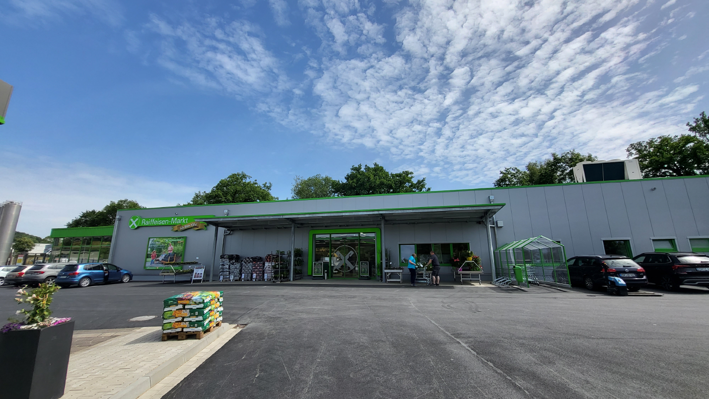 Eingang vom Raiffeisen-Markt Sundern mit Parkplatz & Teil der Tankstelle im Vordergrund