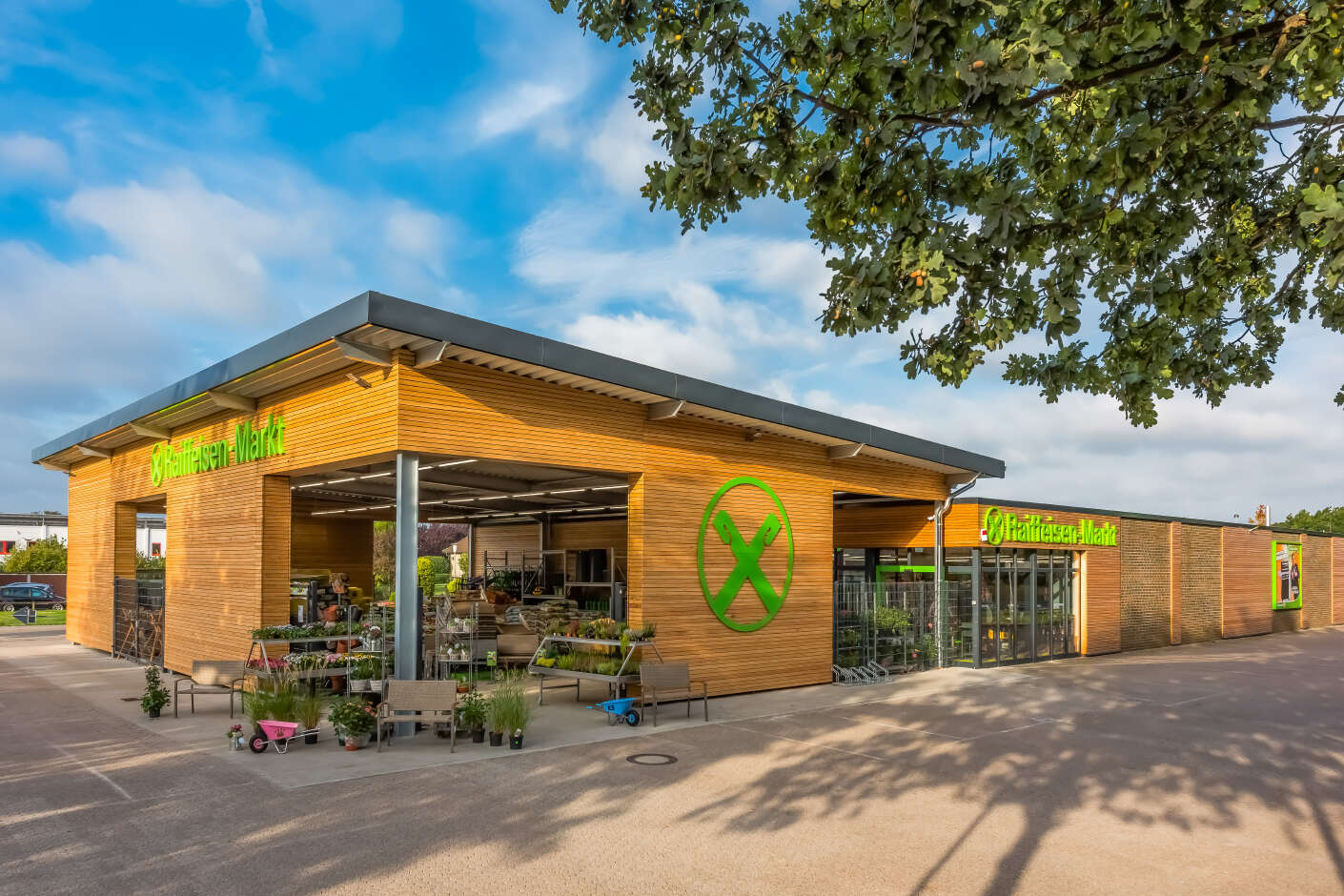 Raiffeisenmarkt mit Holzfassade. Zu erkennen sind Aufsteller mit Garten- und Pfanzenbedarf.