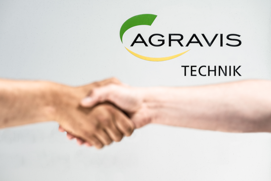 Handshake vor einem Agravis-Technik Logo