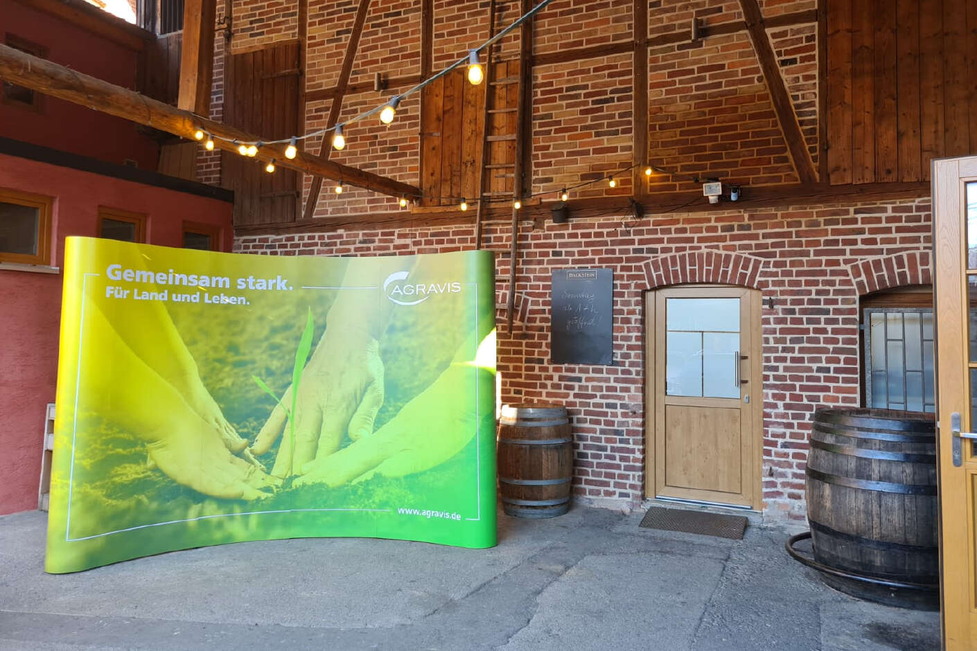 Agrarforum AWH Messewand mit Agravis Motiv steht vor einer urigen Backsteinwand