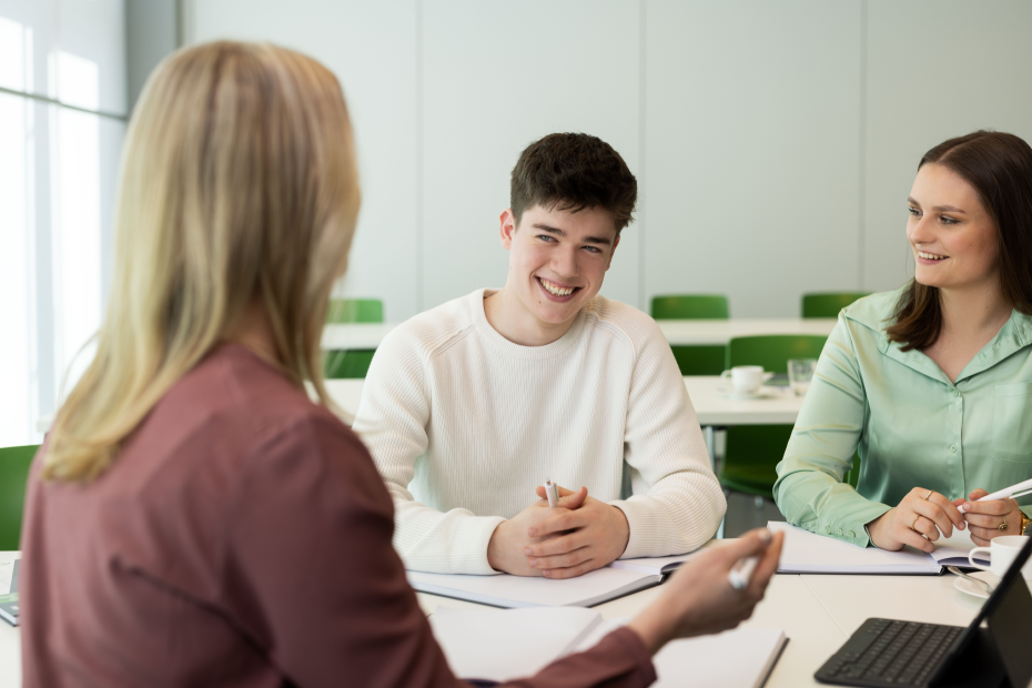 Ausbilder und Azubis sitzen zusammen in einem Meeting