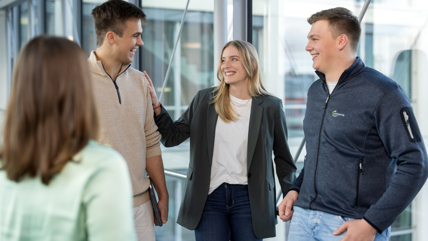 Azubis treffen sich im Flur und unterhalten sich über die Ausbildung