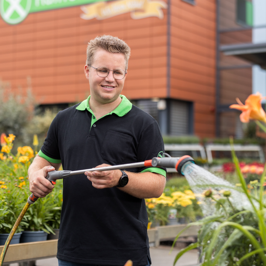 Raiffeisen-Markt-Verkäufer beim pflegen der Pflanzen