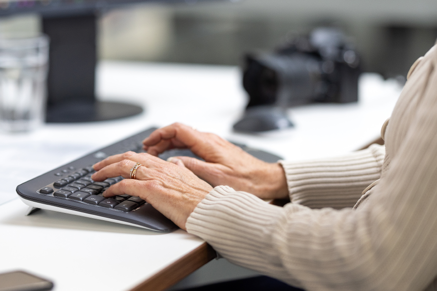 Im Büro - Finger tippen auf Tastatur