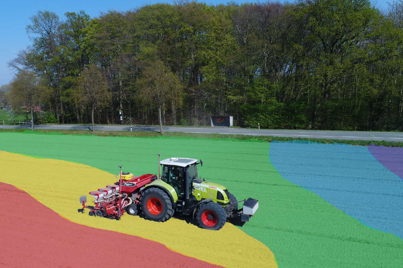 Claas tractor laying maize on a colorful management zone map from Raiffeisen NetFarming