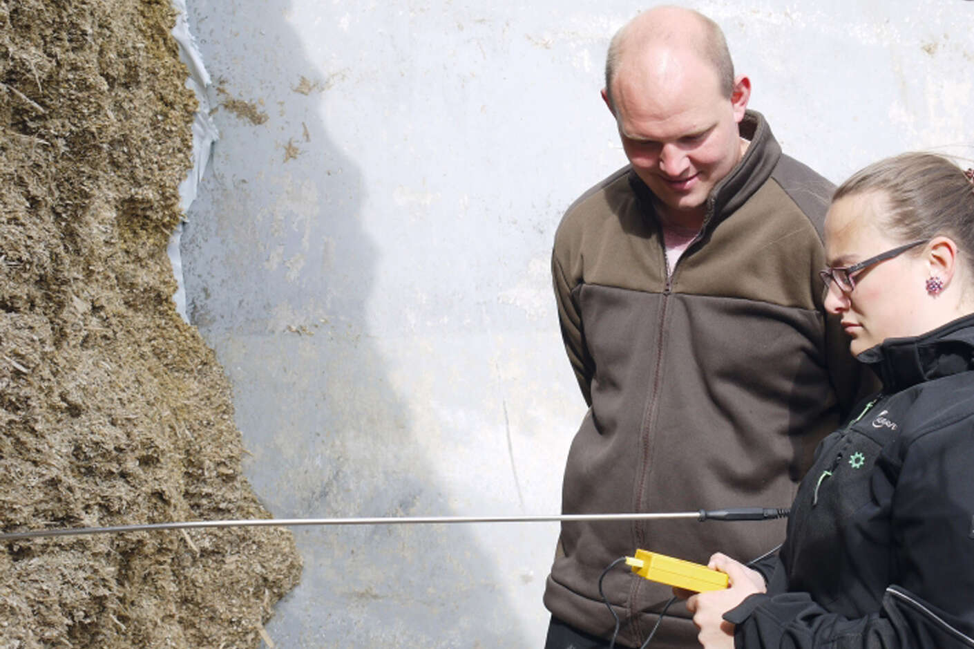 Zwei Personen kontrollieren mit einem Messgerät die Silage.