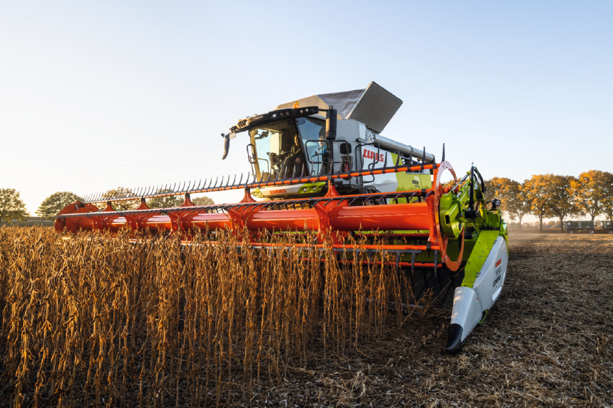 CLAAS Traktor mit Pflug bei der Bodenbearbeitung unter dramatischem Himmel