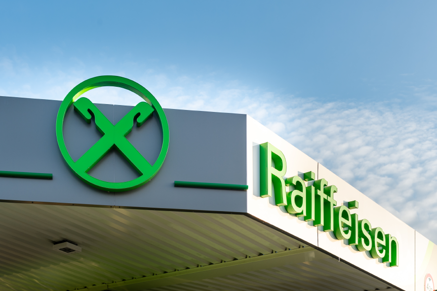 Raiffeisen-Giebelkreuz und Schriftzug an einem Tankstellendach.
