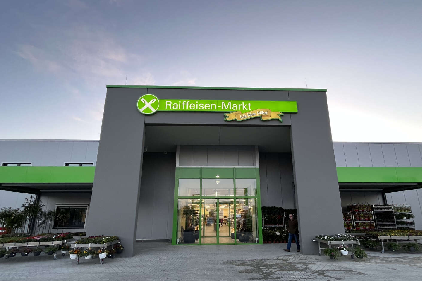 Eingang vom Raiffeisenmarkt in Uetze. Der Eingang wird von einem großen grauen Eingangsportal gekennzeichnet.