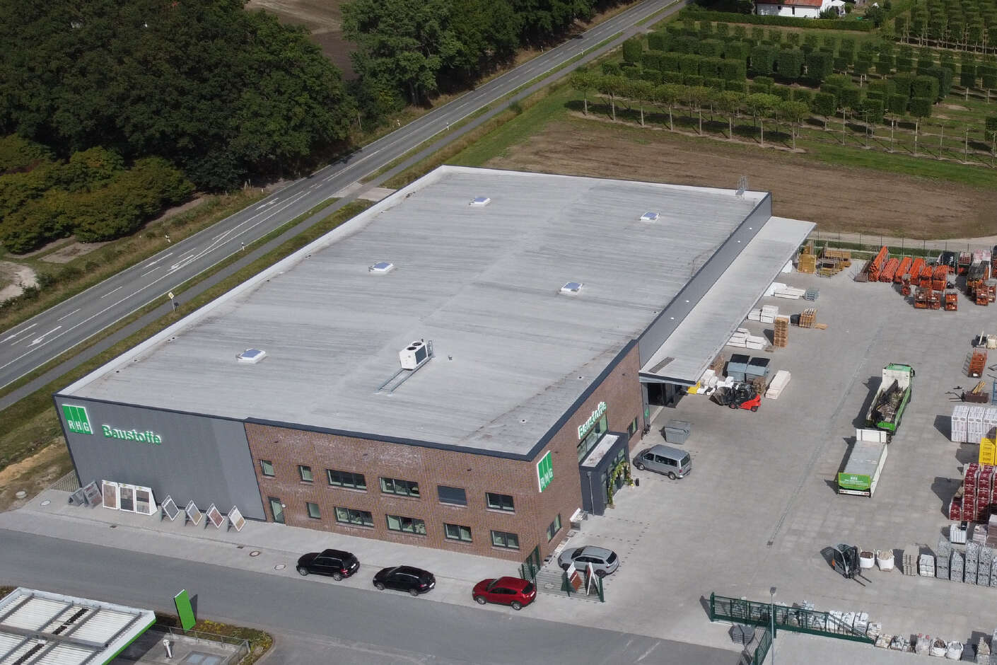 Drohnenaufnahme vom Logistikgebäude und dem Hof auf dem viele Materialien lagern.