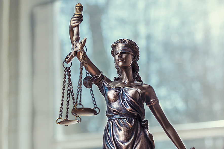 Statue der Justitia mit Waage, verbundenen Augen und Schwert