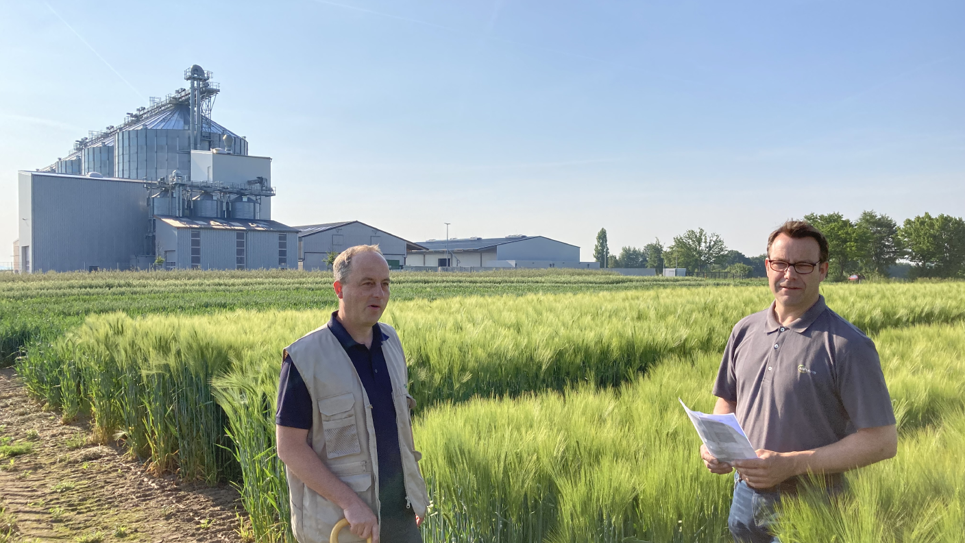 Ferdi Stamm (LWK NRW) & Stefan Bobbert (AWH) im Versuchsfeld mit Standort Hohenwepel im Hintergrund