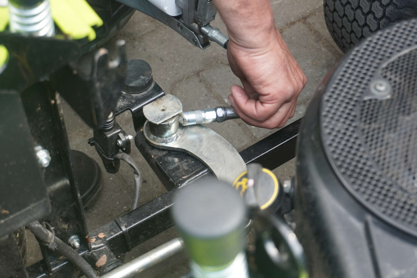 Detailaufnahme eines Mitarbeiter während einer Reparatur am Rasenmäher 