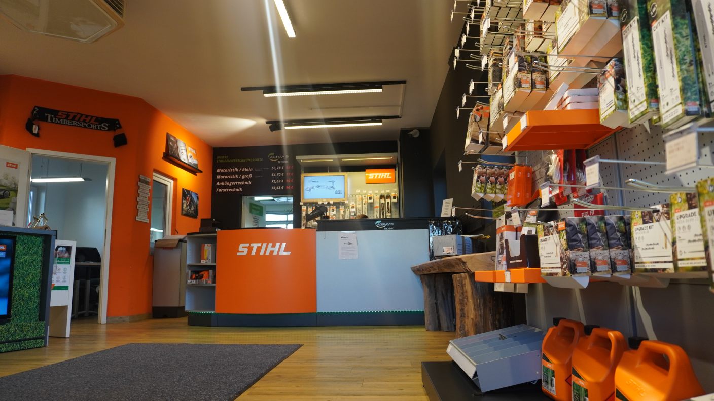 STIHL Verkaufsraum mit Zubehörwand und orange-schwarzem Thekenbereich