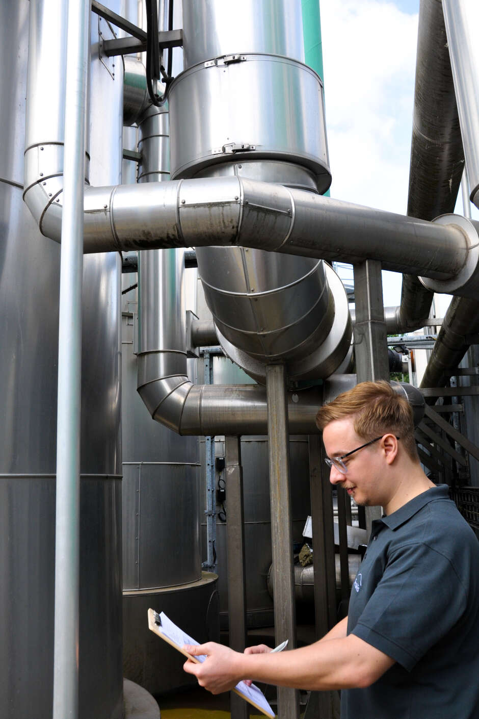 Patrick Behrend steht konzentriert vor einer Biomethanaufbereitungsanlage.