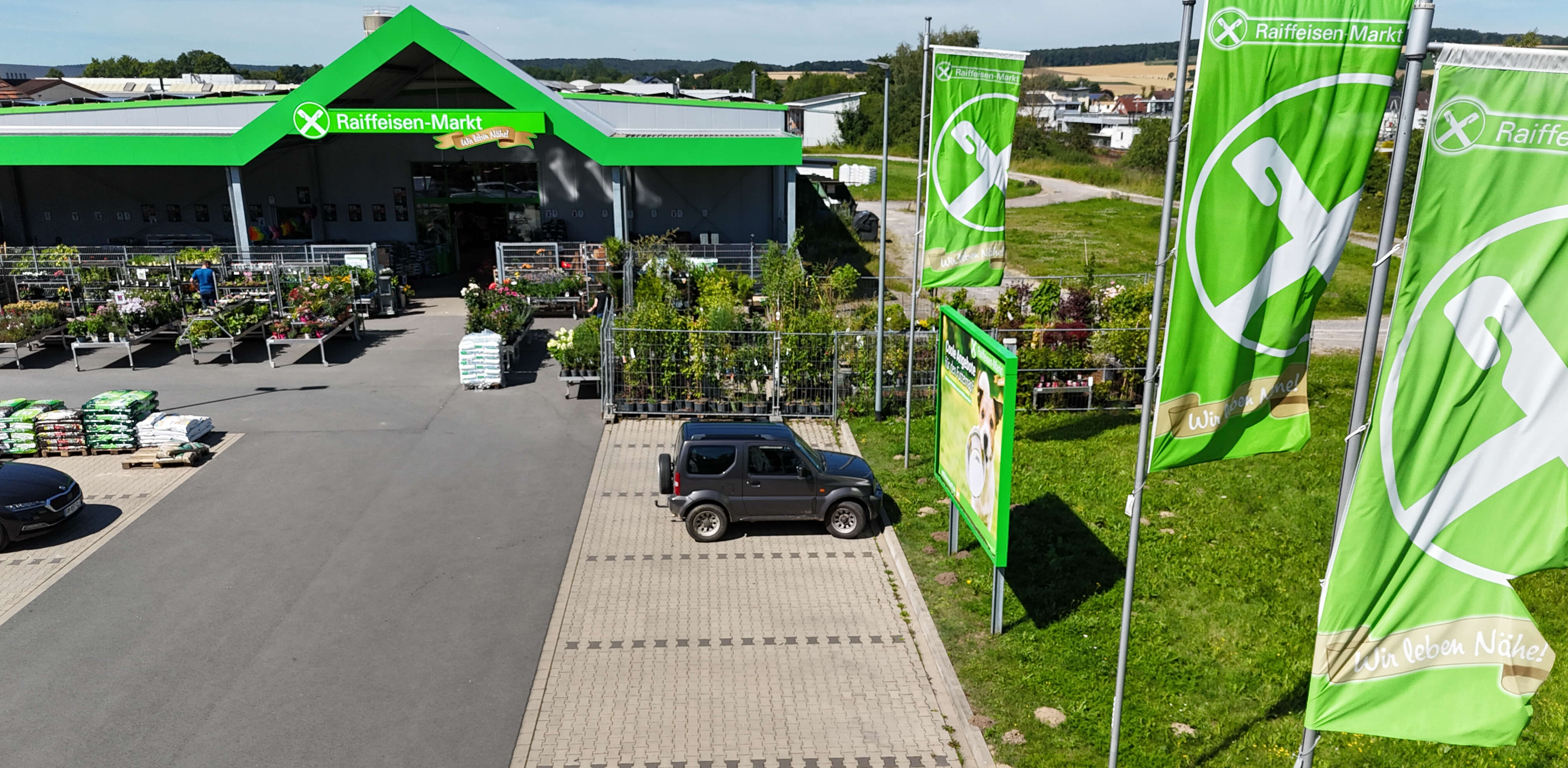 Drohnenbild vom Raiffeisen-Markt Brakel mit Fahnen auf der rechten Seite