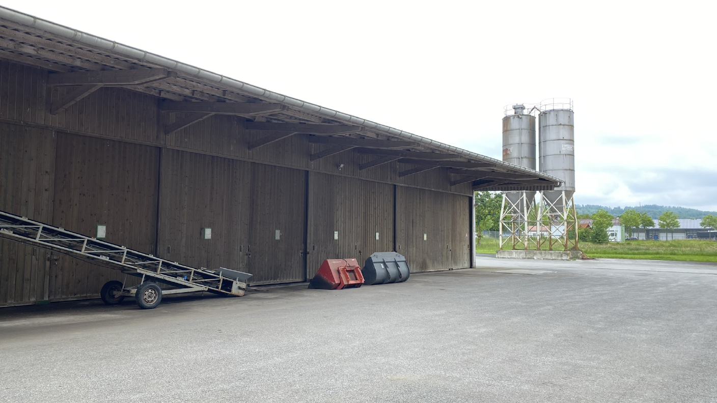 Düngerhalle mit Förderband im Vordergrund und Korbacher Industriegebiet im Hintergrund