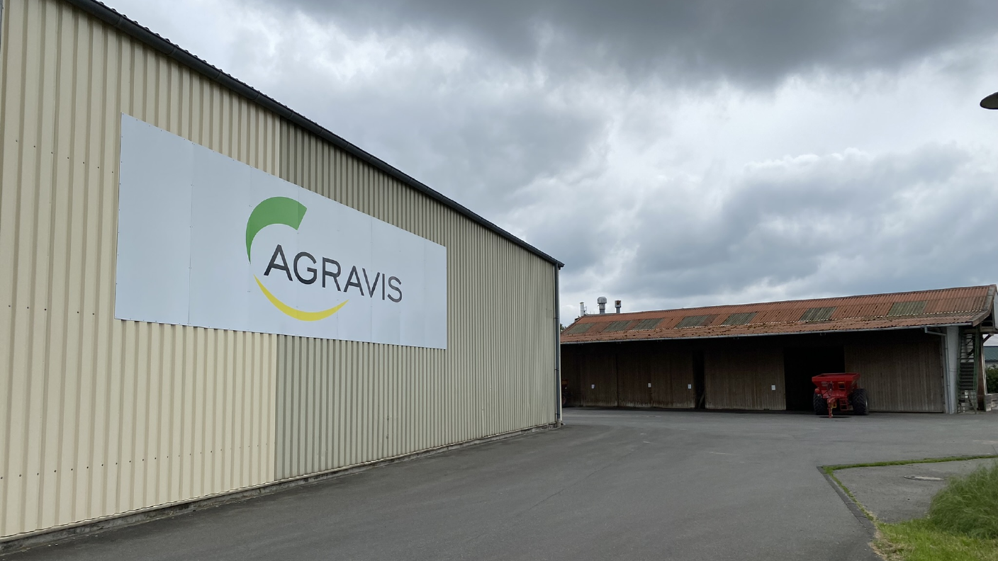 AGRAVIS Schild am Gebäude im Hintergrund Düngerhallen und Kalkstreuer
