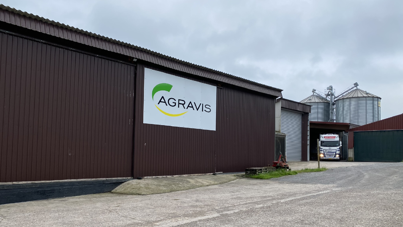 AGRAVIS Schild am Gebäude im Hintergrund Siloanlage bei der ein LKW verladen wird
