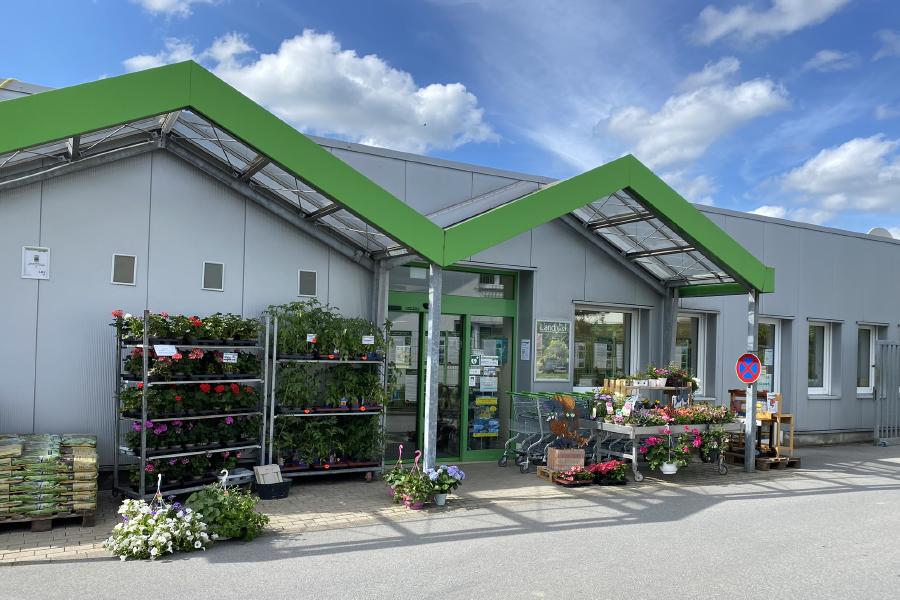 Eingang vom Raiffeisen Markt Bestwig mit Pflanzen & Gartenbedarf im Vordergrund