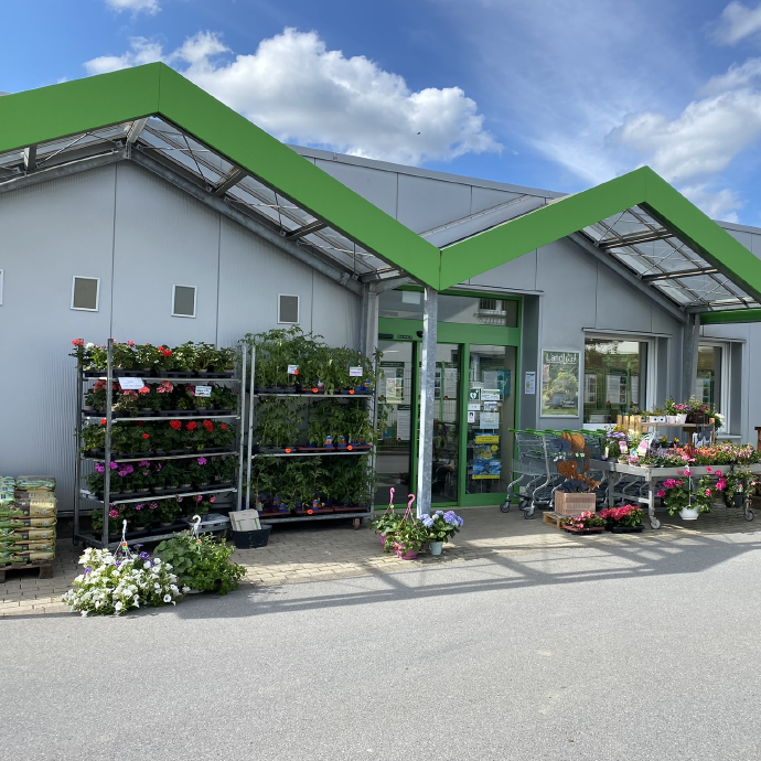 Eingang vom Raiffeisen Markt Bestwig mit Pflanzen & Gartenbedarf im Vordergrund