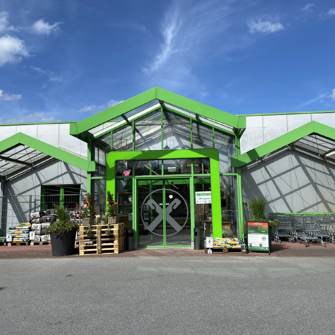 Eingang vom Raiffeisen-Markt Meschede mit Pflanzen, Gartenbedarf & Einkaufswagen im Vordergrund