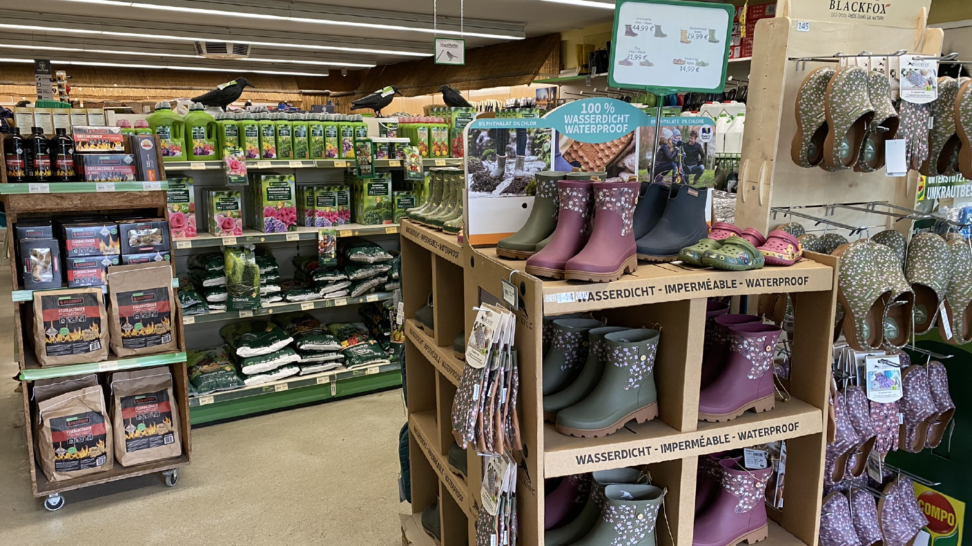 Regale mit Gartenbedarf wie Dünger & Gartenschuhen