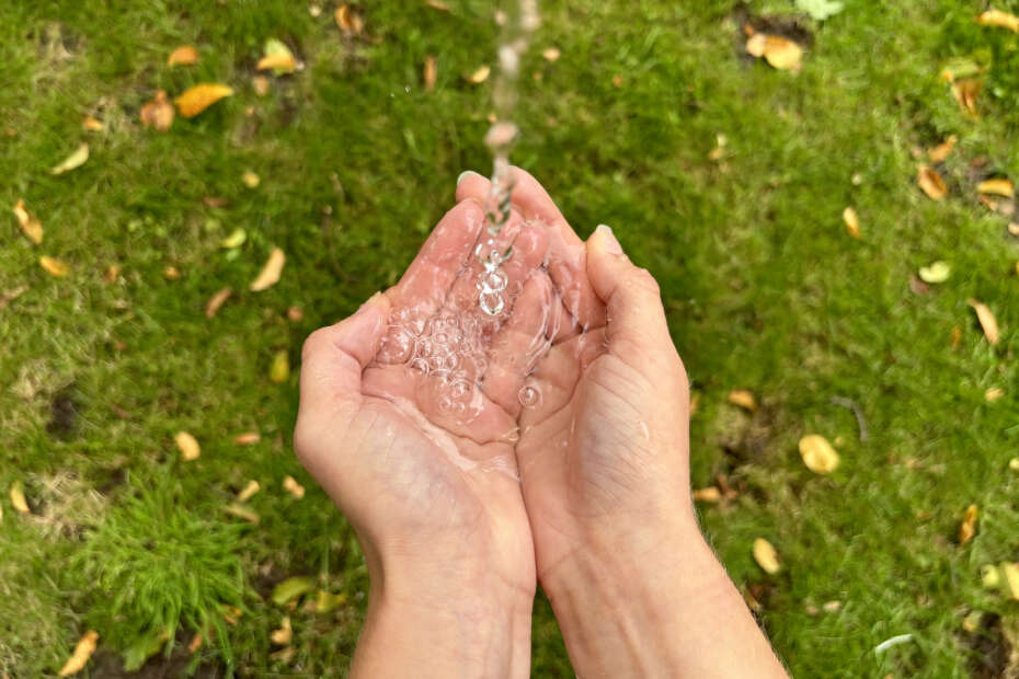 Wasser läuft von oben in zwei Hände