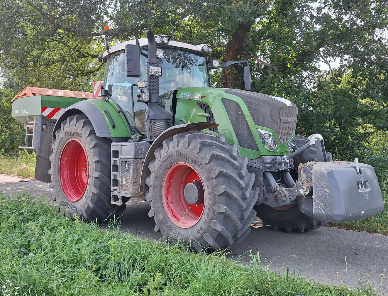 Fendt 828 Vario Traktor mit Frontgewicht und Düngerstreuer