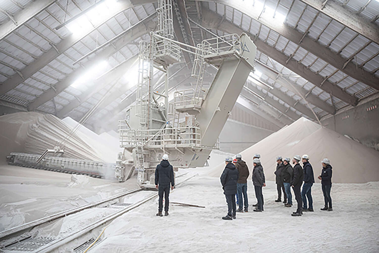 Fabrik mit Zuckerproduktion, in der mehrere Personen stehen. 