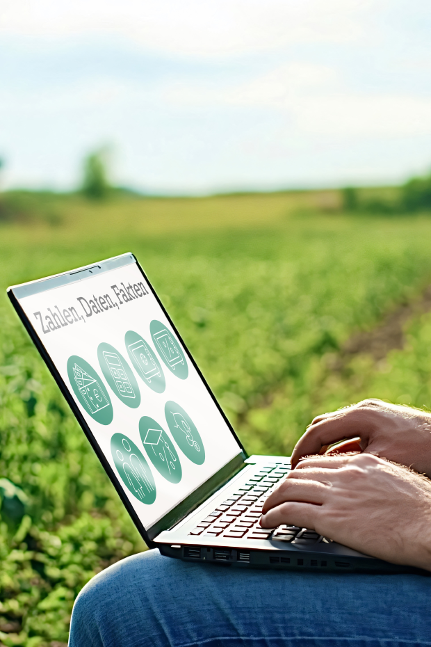 Mann mit Laptop auf Feld - Zahlen, Daten, Fakten auf Bildschirm