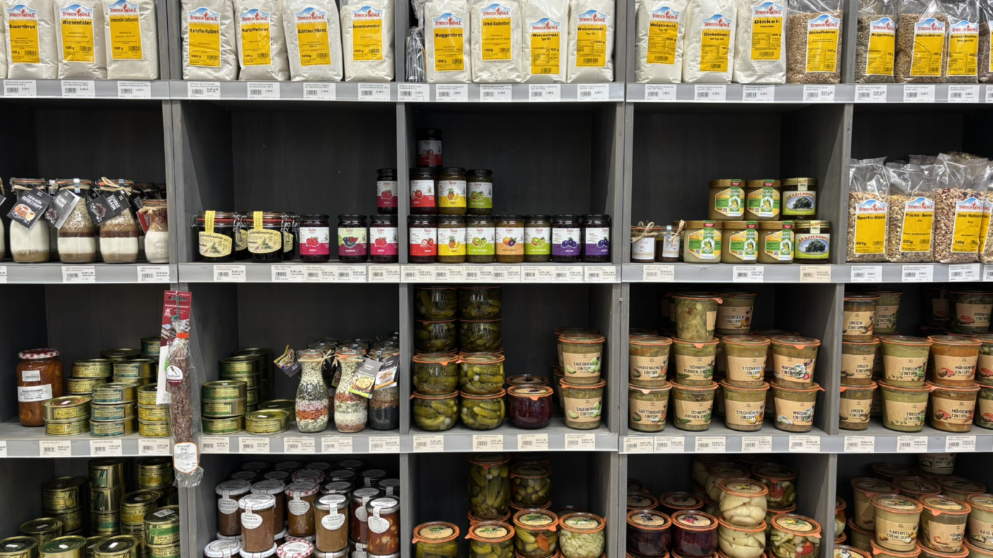 Regal mit Lebensmitteln wie Backmischungen, Marmelade, Eintopf, eingelegtes Gemüse