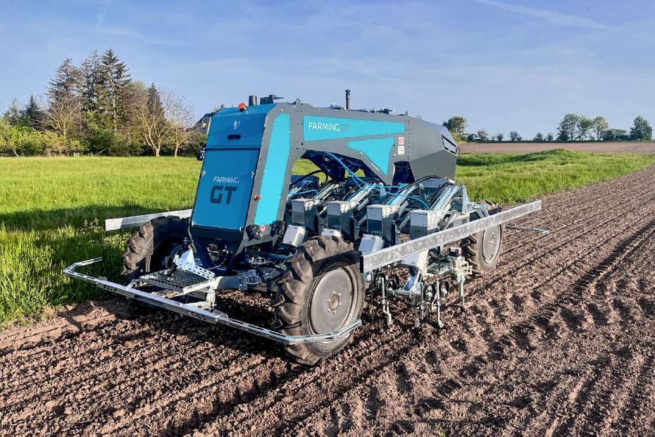Farming GT fährt autonom über frisch bearbeiteten Acker neben einer grünen Wiese