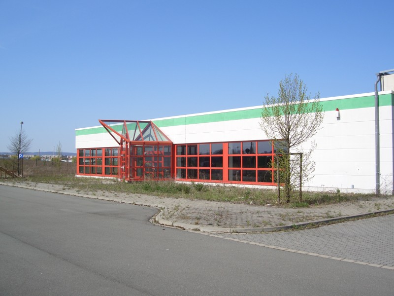 Gewerbehalle mit Glasfront und Zufahrt.
