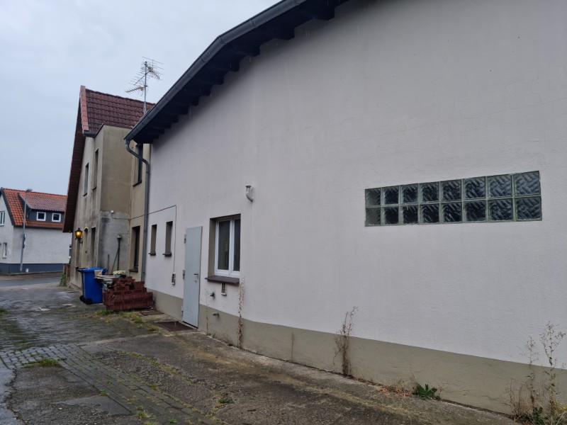 Schlichte Rückseite mit Nebeneingang, Hofzugang und Fensterreihe.