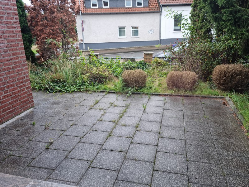Kleiner Balkon mit schmiedeeisernem Geländer und Blick ins Wohngebiet.