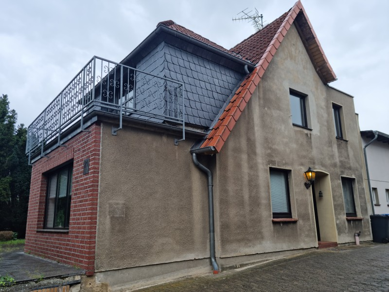 Gemischte Fassade mit Putz und Klinker, Dachgaube mit Balkon.