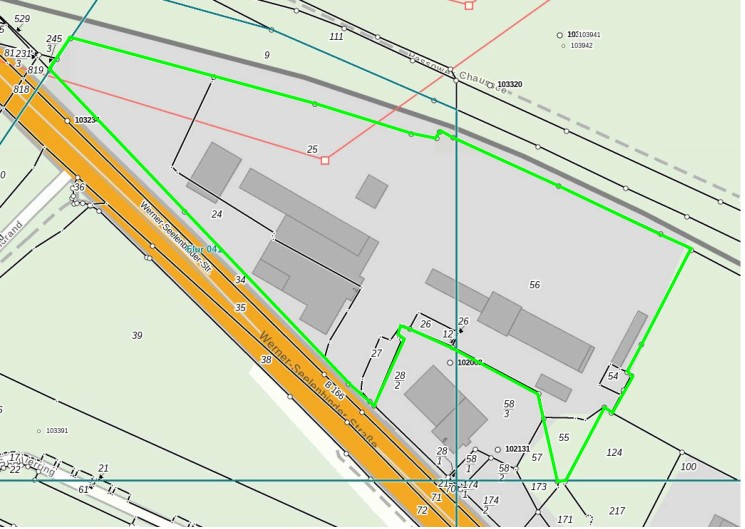 Lageplan eines Gewerbegrundstücks mit mehreren Hallen und Gebäuden. Die Grundstücksgrenzen sind grün umrandet, die Erschließung erfolgt über die stark befahrene „Werner-Seelenbinder-Straße“.