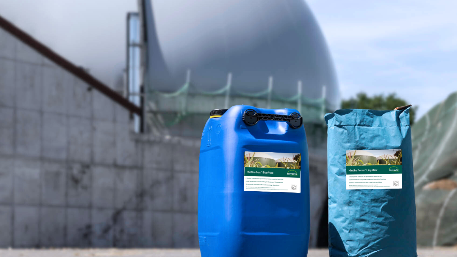 Ein Container Enzyme und ein Sack Spurenelemente vor einer Biogasanlage.