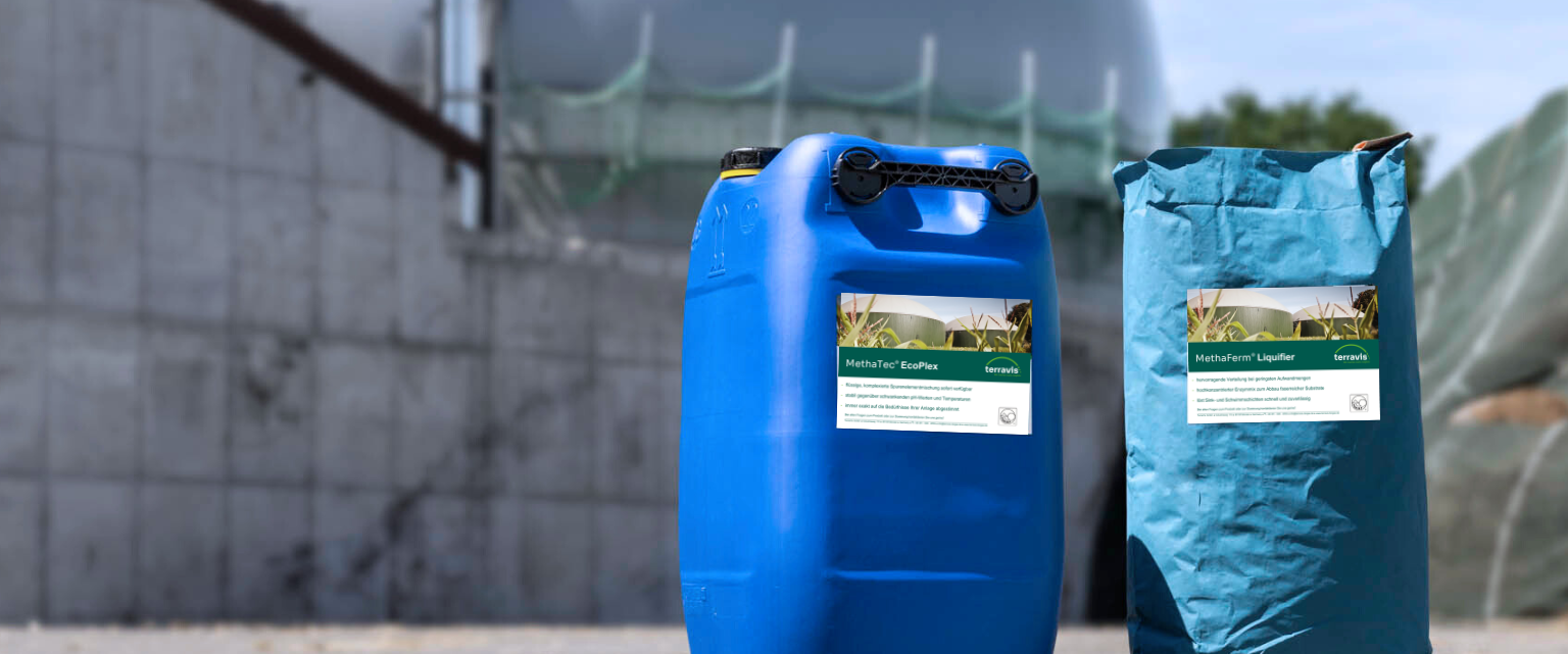 Ein Container Enzyme und ein Sack Spurenelemente vor einer Biogasanlage.
