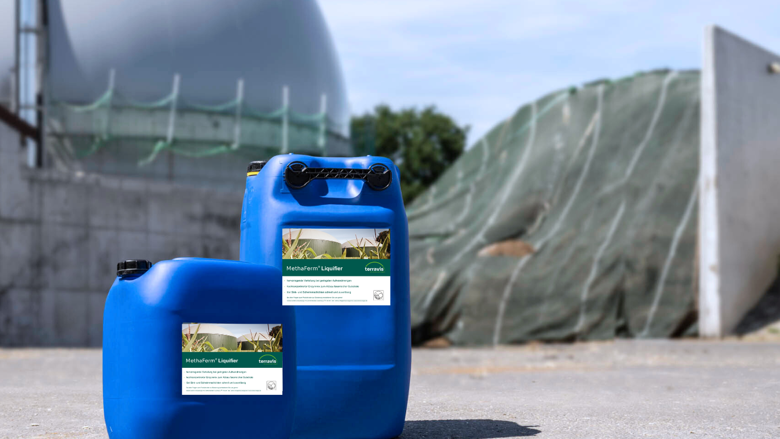 Zwei Container mit Enzymen vor einer Biogasanlage.