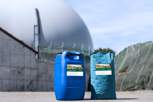 Ein Container Enzyme und ein Sack Spurenelemente vor einer Biogasanlage.