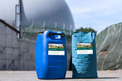 Ein Container Enzyme und ein Sack Spurenelemente vor einer Biogasanlage.