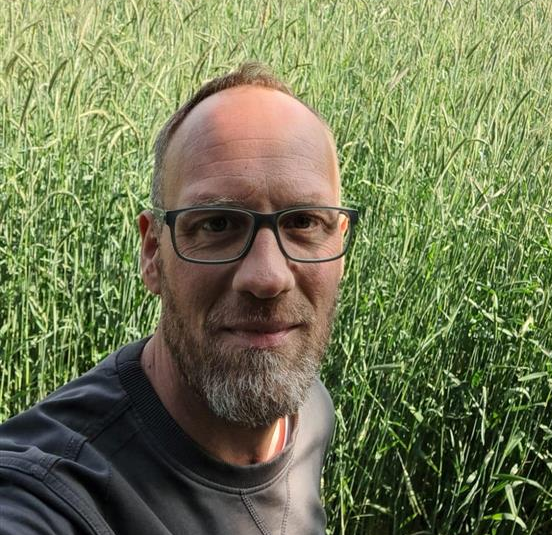 Hendrick Schuckmann vor einem Maisfeld.