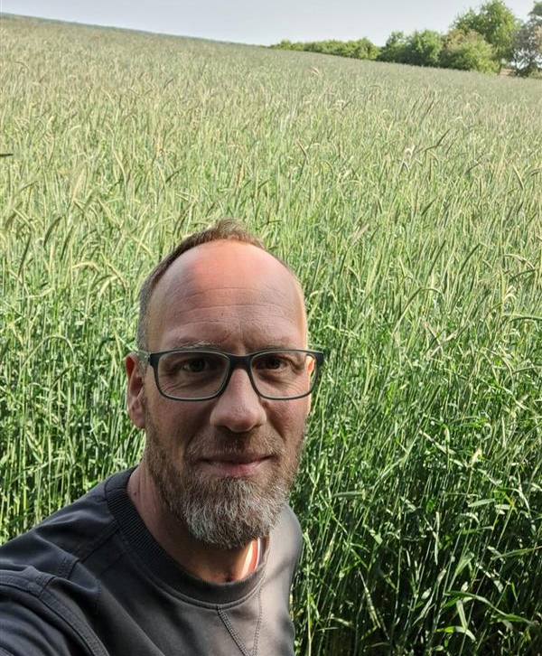 Hendrick Schuckmann vor einem Maisfeld.